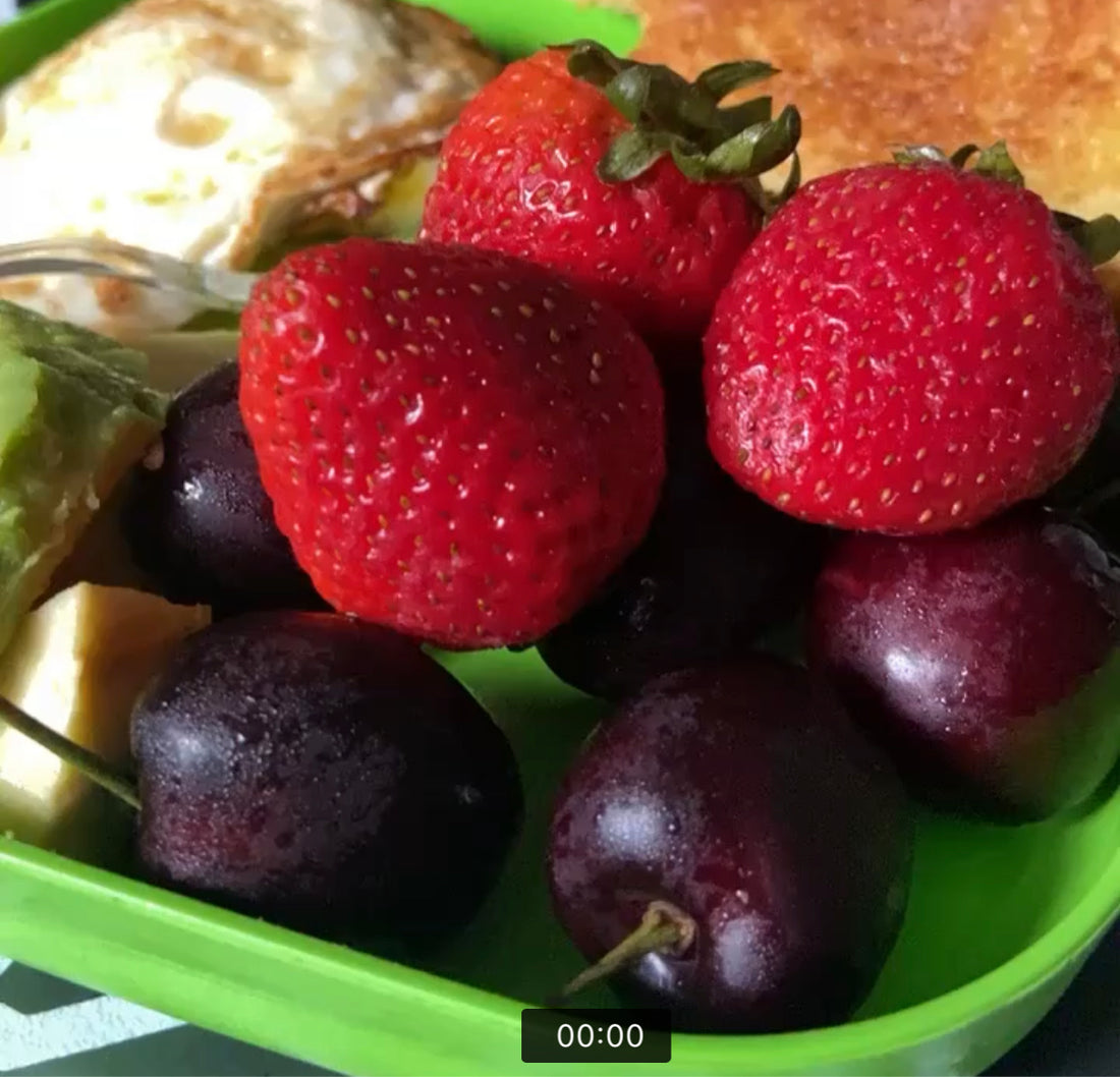 Picture of strawberries, grapes, and other healthy fruit on a green plate 