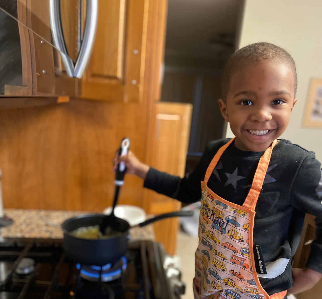 A picture of the chef, a young black boy, cooking using his own seasonings 